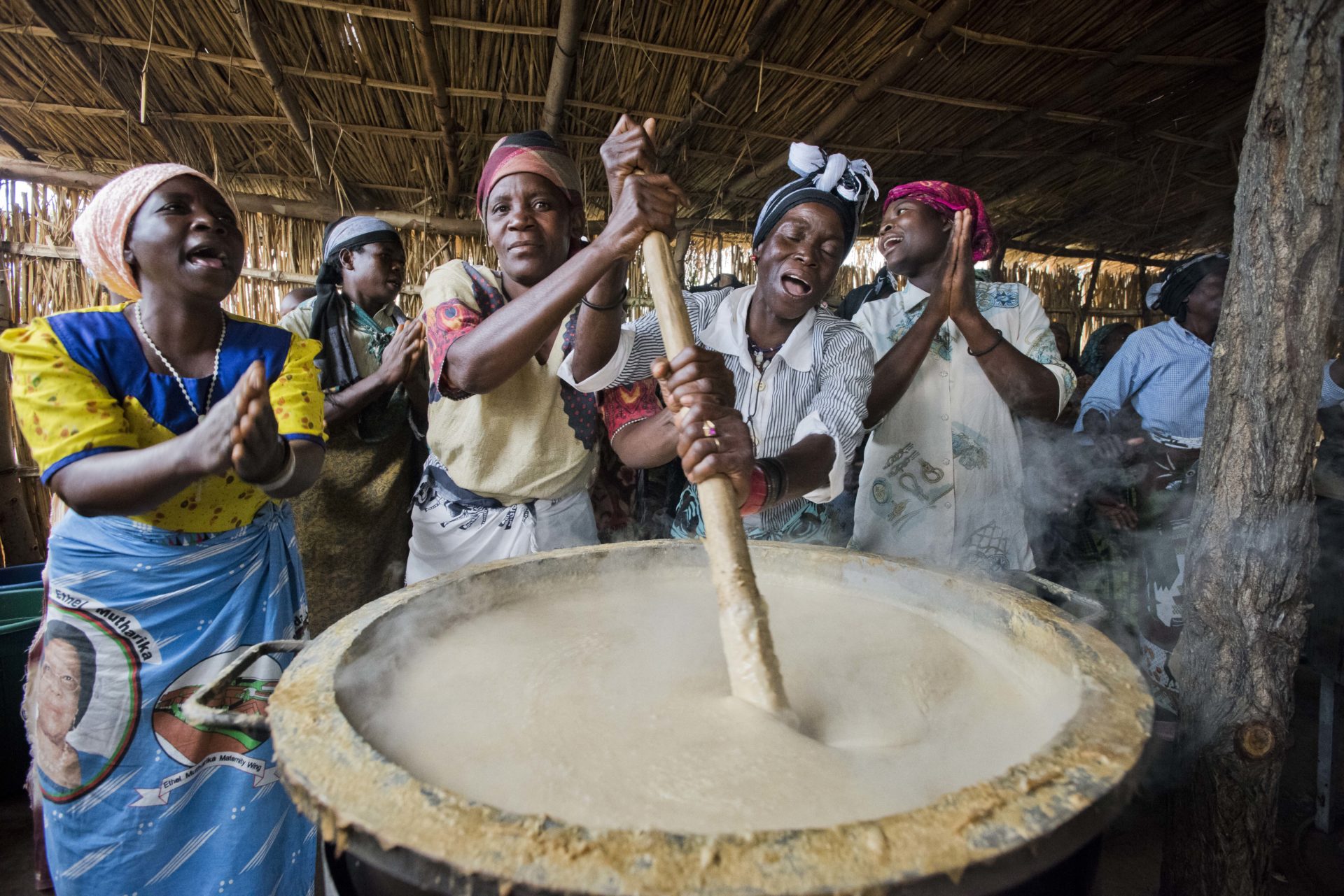 Freiwillige in Malawi helfen bei der Zubereitung der täglichen Mahlzeit für die Schulkinder